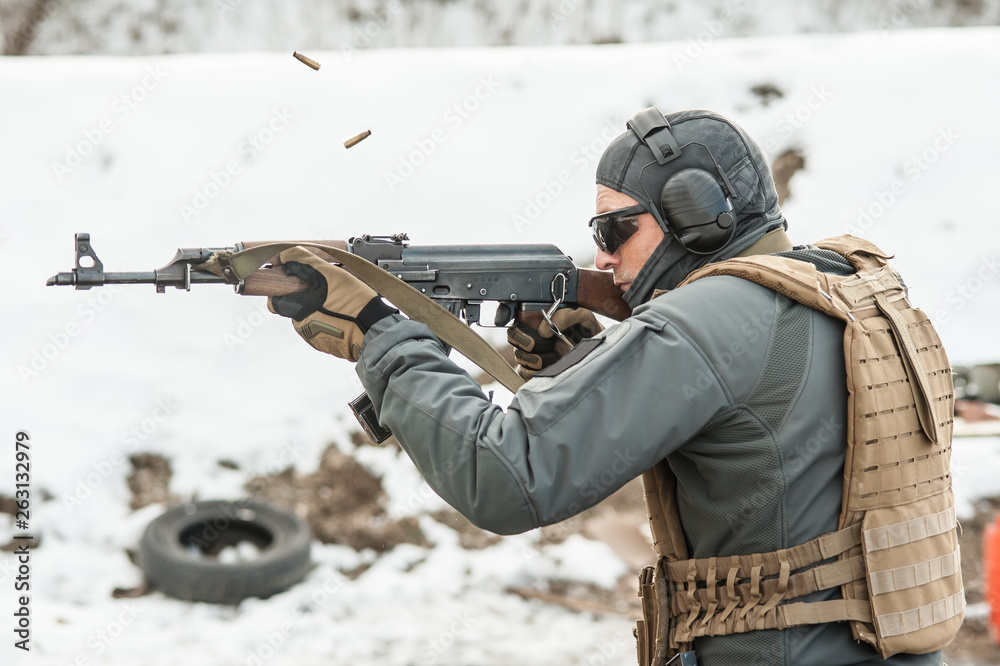 Fototapeta premium Military soldier in action combat shooting from rifle machine gun