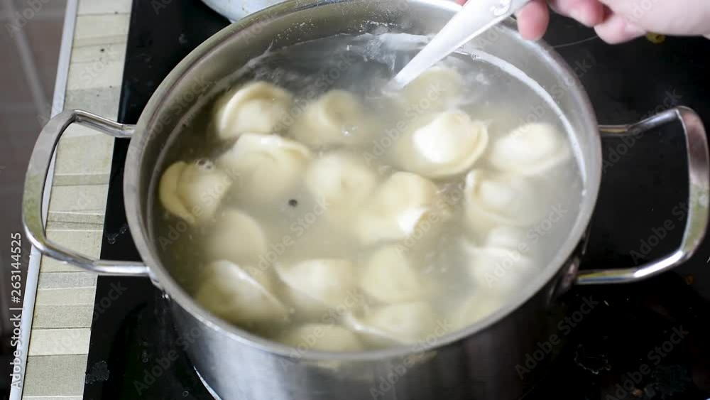 Ravioli boiling in water with spices Close-up of dumplings on a skimmer over a pan of boiling water. Home cooking Ravioli boiling in water with spices Close-up of dumplings on a skimmer over a pan of boiling water. Home cooking