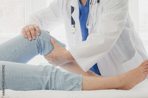 Doctor giving a patient a leg treatment photo
