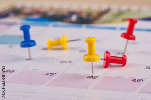 close up of colorful pin on calendar for business appointment or planning concept