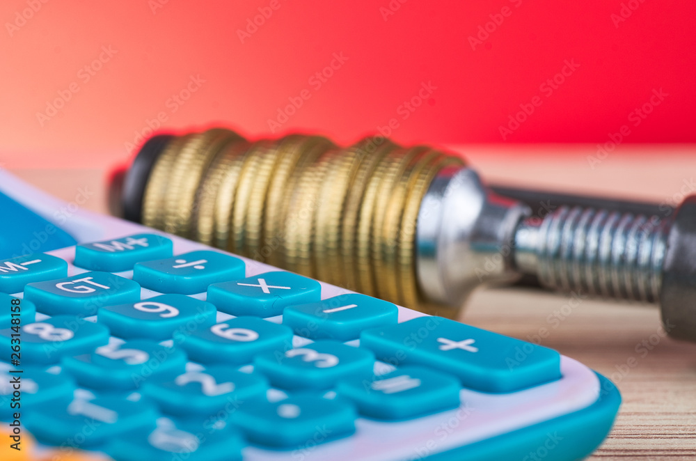 devaluation and financial crisis, calculator and coins squeezed tightly in a G-Clamp devaluation and financial crisis, calculator and coins squeezed tightly in a G-Clamp