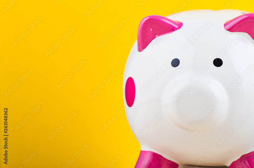 close-up image of white piggy bank over yellow background for saving concept close-up image of white piggy bank over yellow background for saving concept