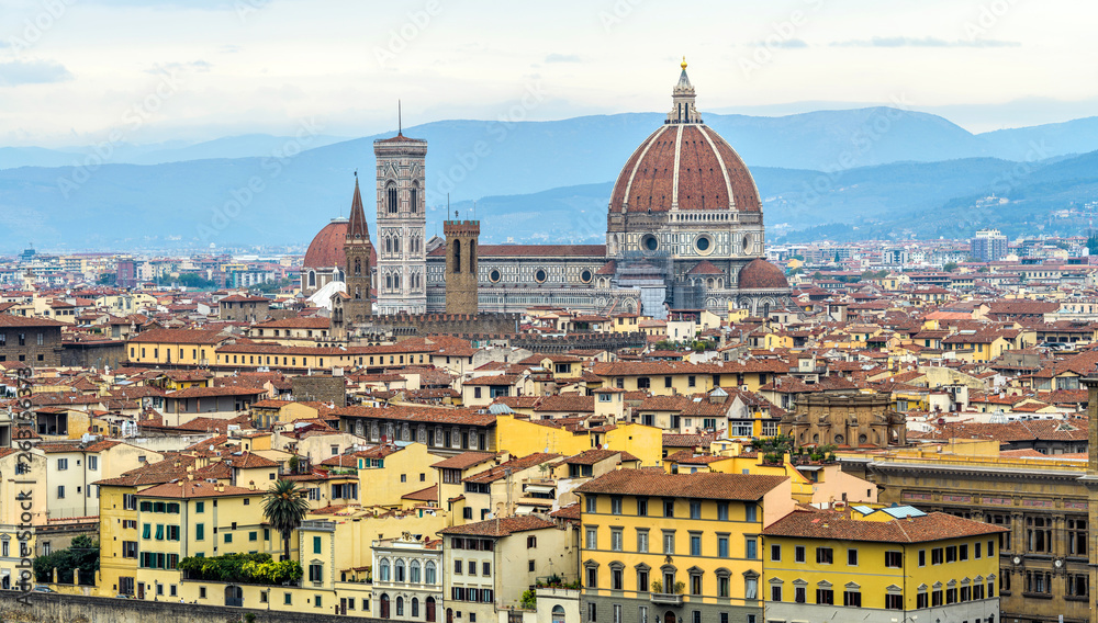 Autumn in Florence - A panoramic view of the skyline of the Florence Cathedral, against blue rolling hills and cloudy sky, in the historical Old Town of Florence on a rainy Autumn day. Tuscany, Italy.