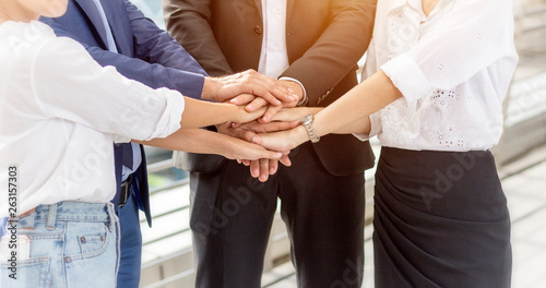Unity and teamwork concept; Close up top view of business people putting their hands together. Stack of hands.