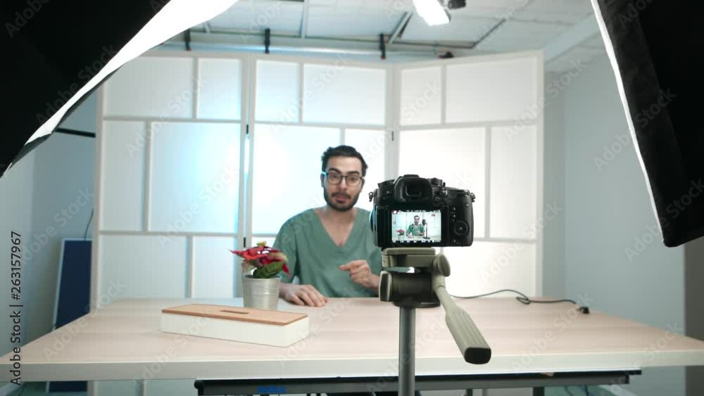 Young male vlogger recording a video of himself talking to the camera to be then published on the internet.