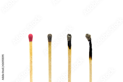Close up one new wooden match stick standing among burnt matches stick.