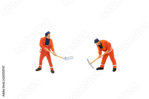 Miniature figurine character as construction worker standing and working in posture isolated on white background.