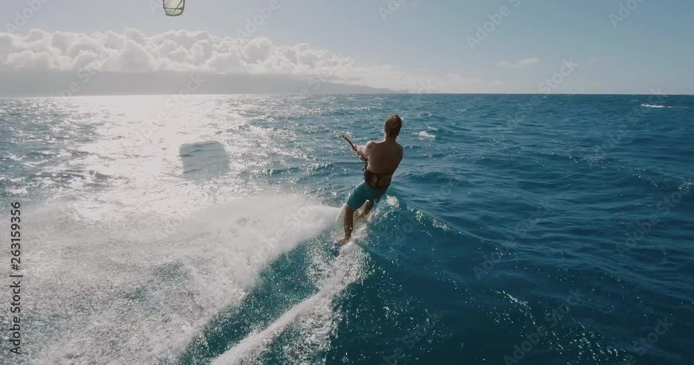 Young athletic man kitesurfing POV follow cam, extreme action sports POV, tropical island surf adventure