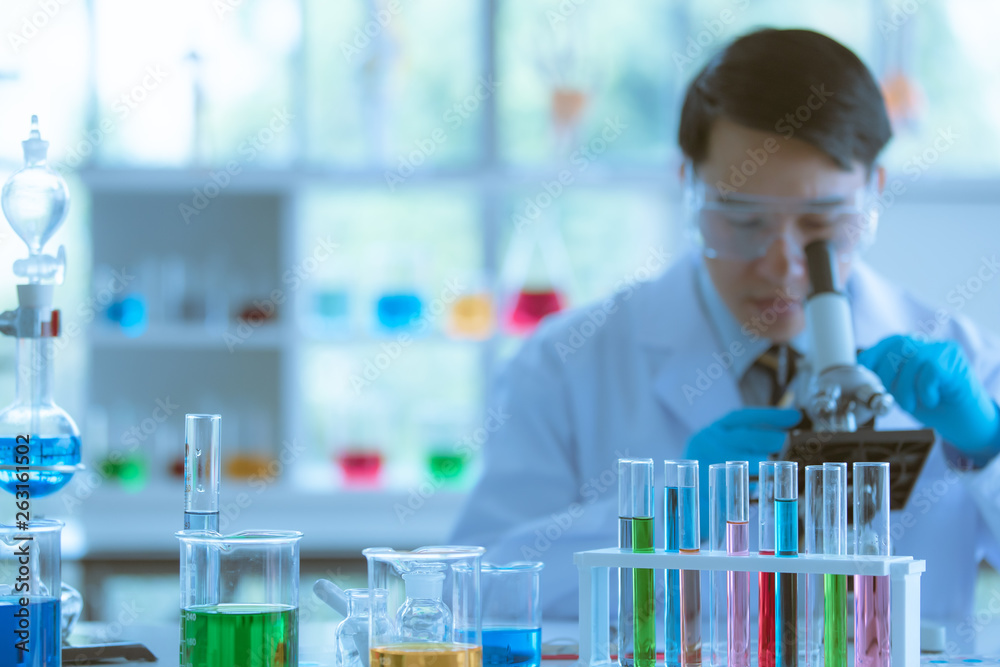 Scientist adjusting microscope for experiment. Scientist adjusting microscope for experiment.