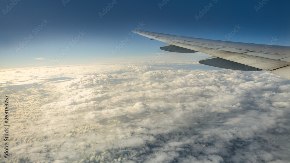 Close up of window with airplane wing. Beautiful cloudscape with clear blue sky. Close up of window with airplane wing. Beautiful cloudscape with clear blue sky.