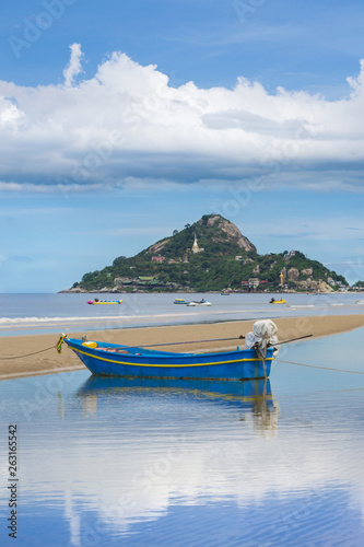 Fishing boat at sunshine on the beach with mountain background. photo
