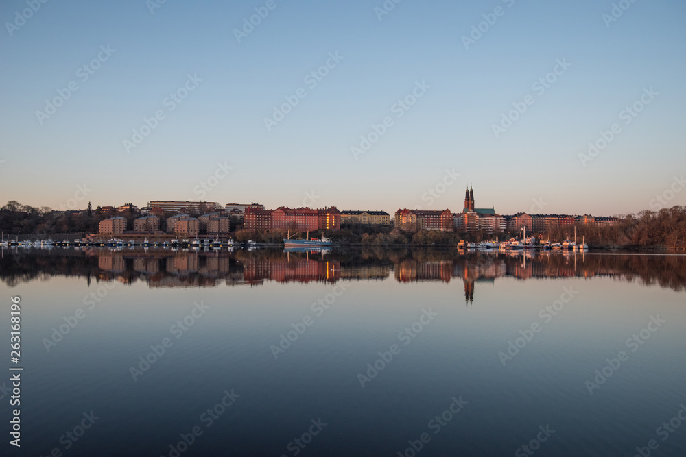 Obraz premium View over old houses in the Södermalm district a spring day at sunrise in Stockholm from the Norrmälarstrand pier