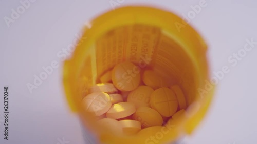 Macro close-up of a bottle full of amphetamine / dextroamphetamine pills spinning on a white surface photo