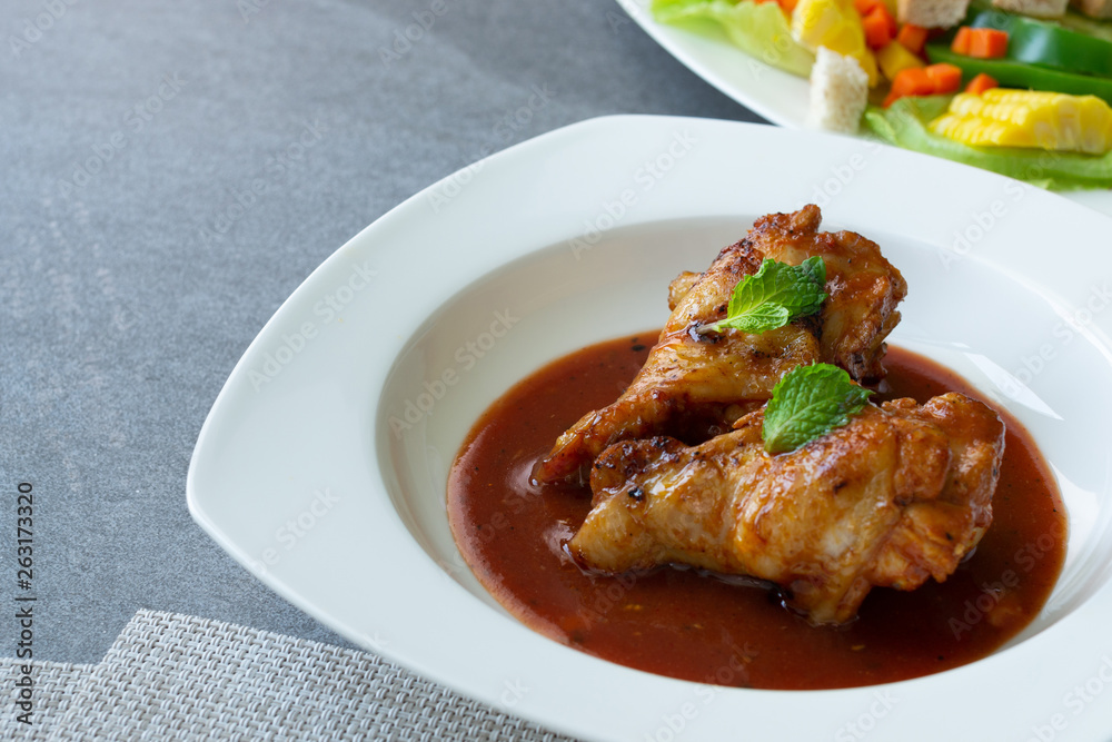 Spicy drumstick or Fried chicken with tomato sauce and black pepper in white dish on concrete table. Spicy drumstick or Fried chicken with tomato sauce and black pepper in white dish on concrete table.