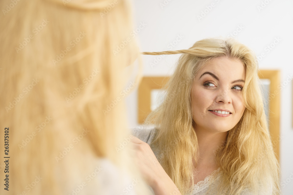 Fototapeta premium Woman in bathroom styling hair