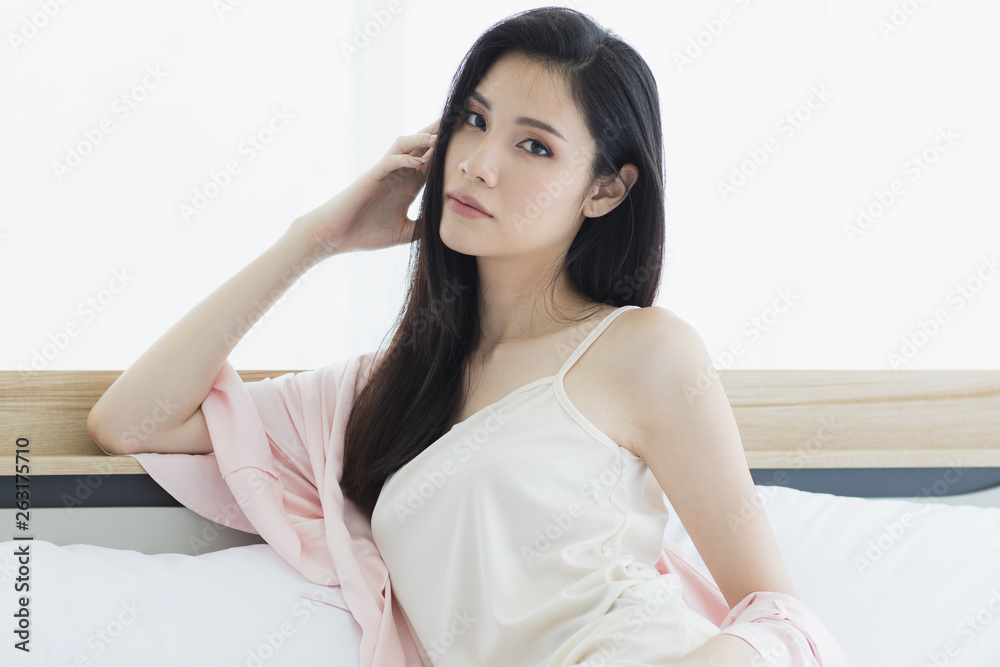 Asian woman model sitting and posing on bed.. Asian woman model sitting and posing on bed..