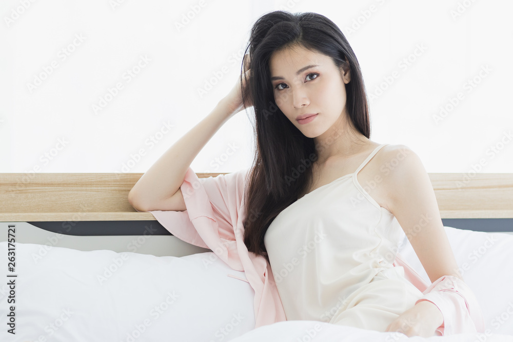  Asian woman model sitting and posing on bed..