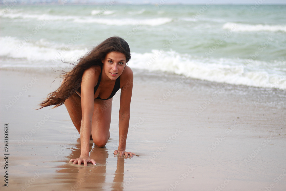 Woman on the beach enjoying the summer by the sea Woman on the beach enjoying the summer by the sea