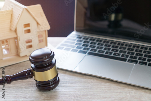Lawyer business real estate property agent, home loan or divorce. Concept of Conflict lawsuit from not paying home debt, therefore requiring judgment prosecution. Judge hammer with house on Computer