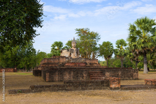 Sculpture of a seated Buddha on the ruins of the Buddhist temple Wat Mae Chon in the early morning. Sukhothai, Thailand