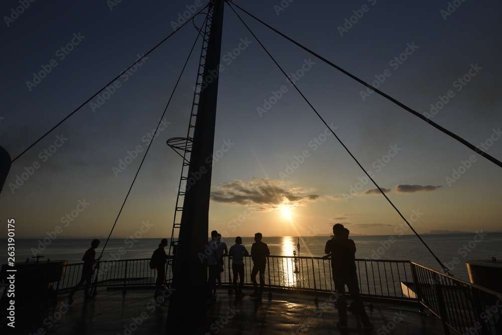 People silhouette on a stern ship with twilight sea and sky in an evening
