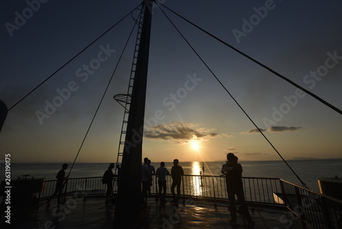 People silhouette on a stern ship with twilight sea and sky in an evening
