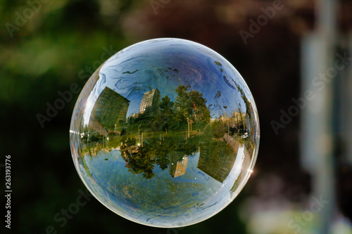 Lonely Colorful Soap Bubble with Reflection of the City and Sky Inside It