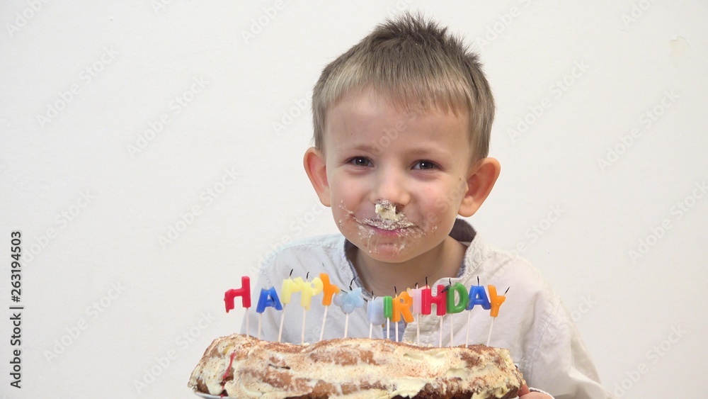 Portrait of funny child eating birthday cake, amusing dirty face smiling and laughing, taste of childhood Portrait of funny child eating birthday cake, amusing dirty face smiling and laughing, taste of childhood