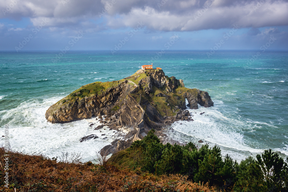 Small isle with San Juan de Gaztelugatxe hermitage on the Atlantic shore in Biscay region of Sapin