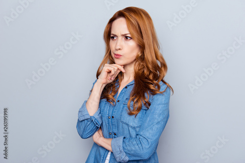Close up photo beautiful amazing she her lady not smiling look side empty space hmm arm finger chin not sure right way learn study teach wear casual blue jeans denim shirt isolated grey background