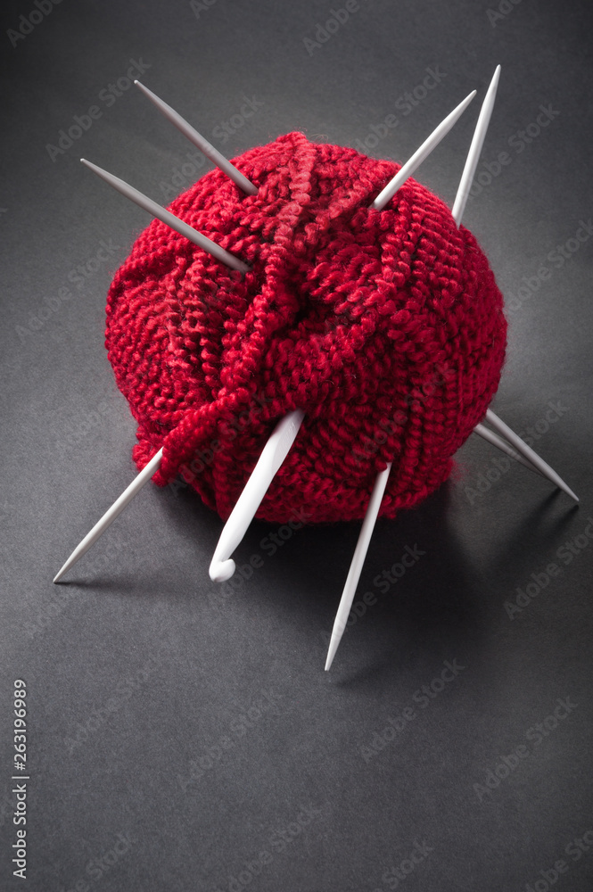 Foto Stock Red ball of wool and knitting needles | Adobe Stock
