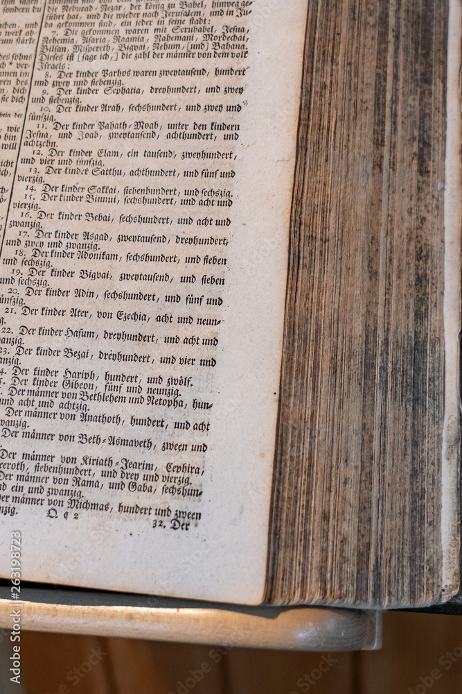 Obraz premium Bible is a open book. Part of the book standing on a wooden book stand. Close-up, vertical shot, Concept for tradition and freedom.