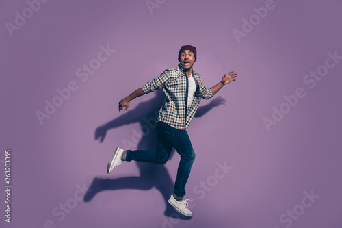 Ful length body size photo portrait of cheerful excited in denim modern trousers white shoes sneakers guy student isolated violet background