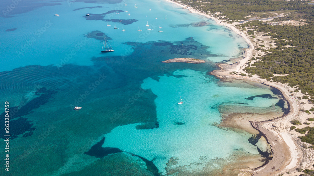 Fototapeta premium Amazing drone aerial landscape of the charming area of Es Trencs and the boats with a turquoise sea. It has earned the reputation of Caribbean beach of Mallorca. Spain