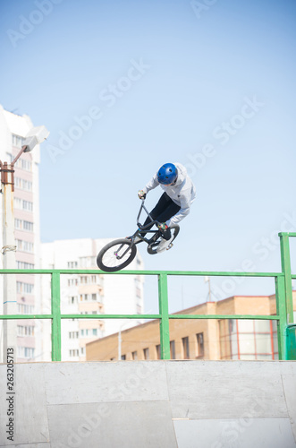 A man performs tricks on a bicycle in the skatepark