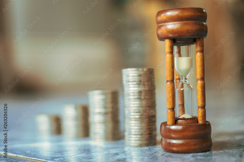 Φωτογραφία step of coins stacks with sandglass or hourglass, saving and investment or family planning concept, motion blured background