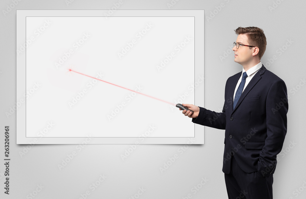 Young businessman with laser pointer and copyspace white blackboard Young businessman with laser pointer and copyspace white blackboard