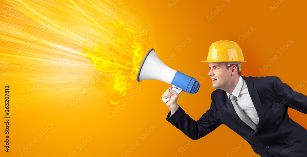 Fototapeta premium Young architect constructor yelling with megaphone with copyspace