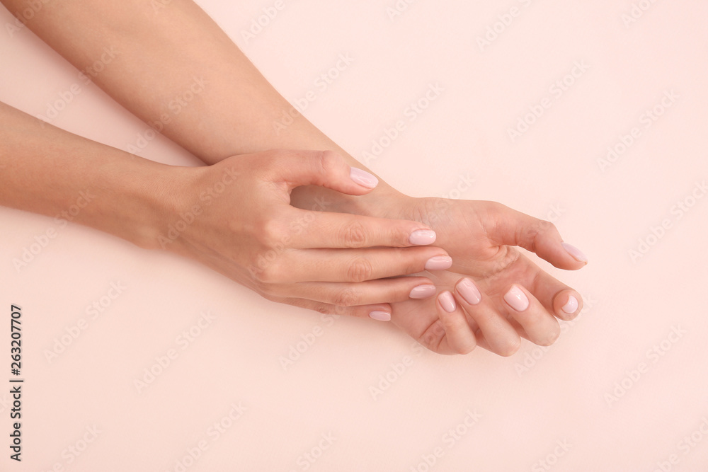 Closeup view of woman with beautiful hands on color background. Spa treatment