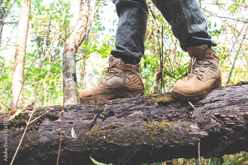 close-up hiking boots. male tourist steps on a log