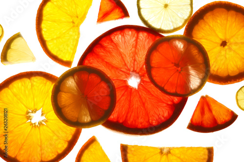 Fototapeta Naklejka Na Ścianę i Meble -  Illuminated slices of citrus fruits on white background, top view