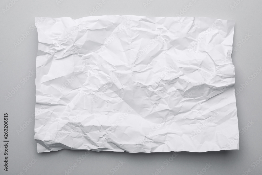 Sheet of crumpled paper on grey background, top view Sheet of crumpled paper on grey background, top view