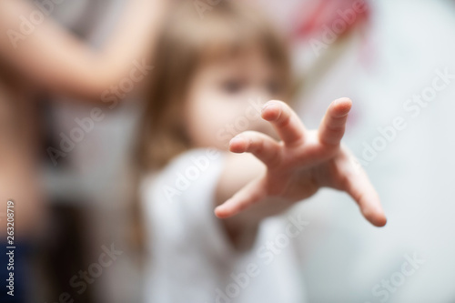 the child pulls his hand into the camera. selective focus on the tips of the fingers