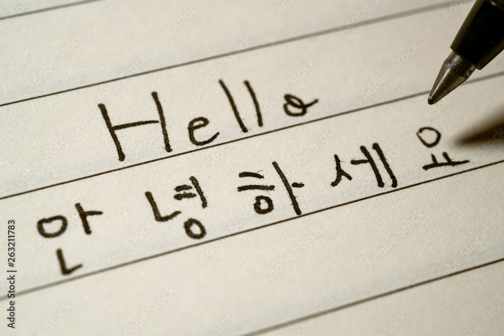 Beginner Korean language learner writing Hello word in Korean characters macro shot Beginner Korean language learner writing Hello word in Korean characters macro shot