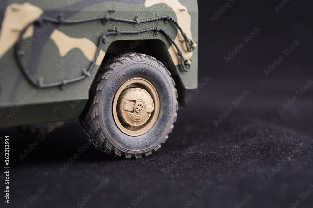 Russian military armored camouflage jeep Tiger. Closeup view. Plastic scale model on dark background