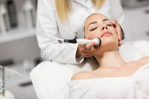 Beautiful woman in professional beauty salon during photo rejuvenation procedure photo