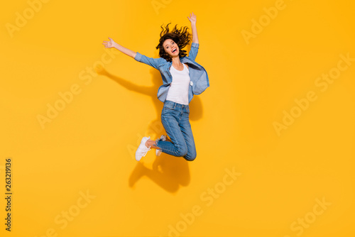 Full length body size view photo playful childish cute lady move holidays glad laughter raise hands travel summer candid freedom active energetic denim suit sneakers legs isolated vibrant background