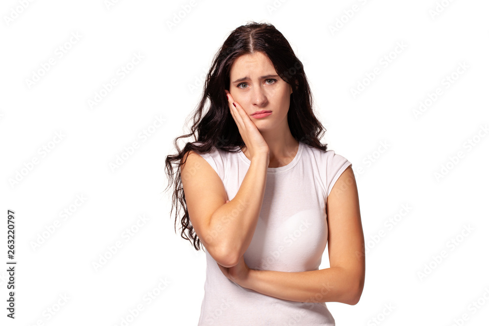 Beautiful and unhappy young woman with dark wavy hair looking into the camera with serious expression on her face. Beautiful and unhappy young woman with dark wavy hair looking into the camera with serious expression on her face.