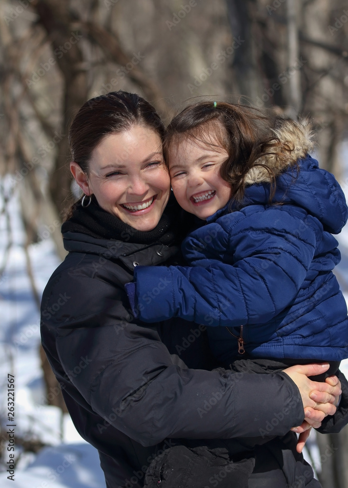 mother and child having fun outdoor during winter