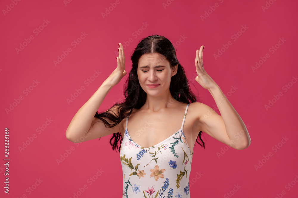 Portrait of a pretty young woman in a light dress standing on pink background in studio. People sincere emotions. Portrait of a pretty young woman in a light dress standing on pink background in studio. People sincere emotions.